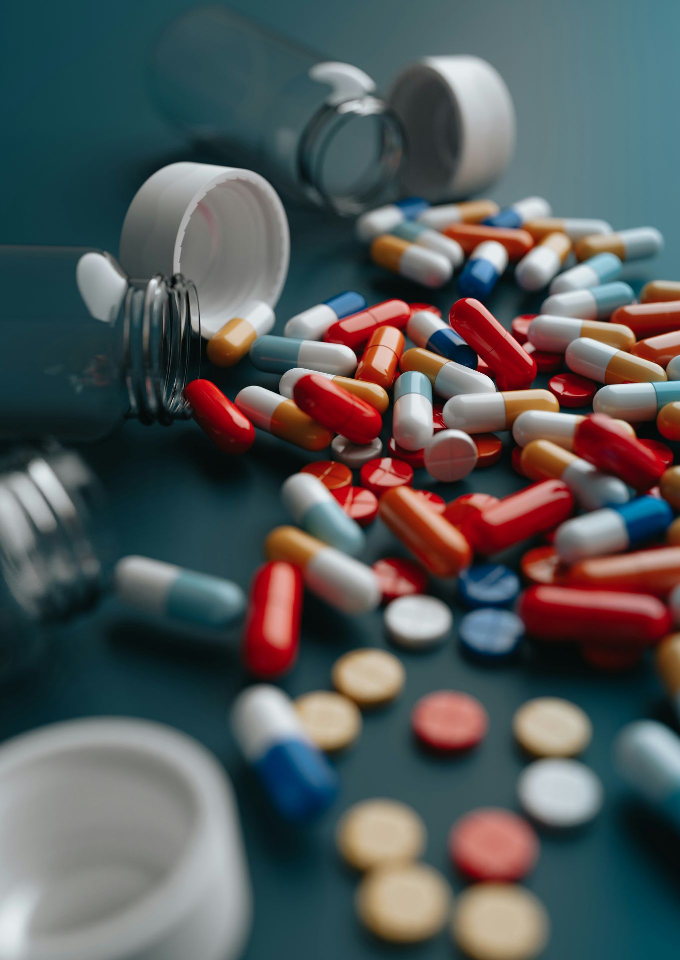 Colorful capsules spilling from bottles