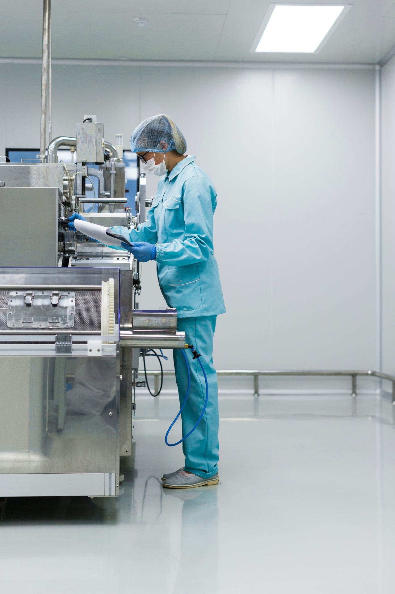 Technician reviewing a batch record beside equipment