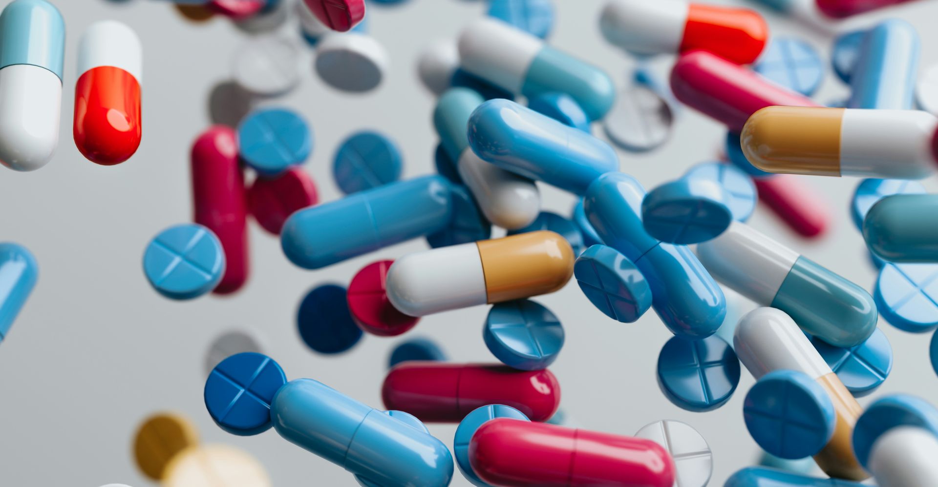 Assorted capsules and tablets in motion